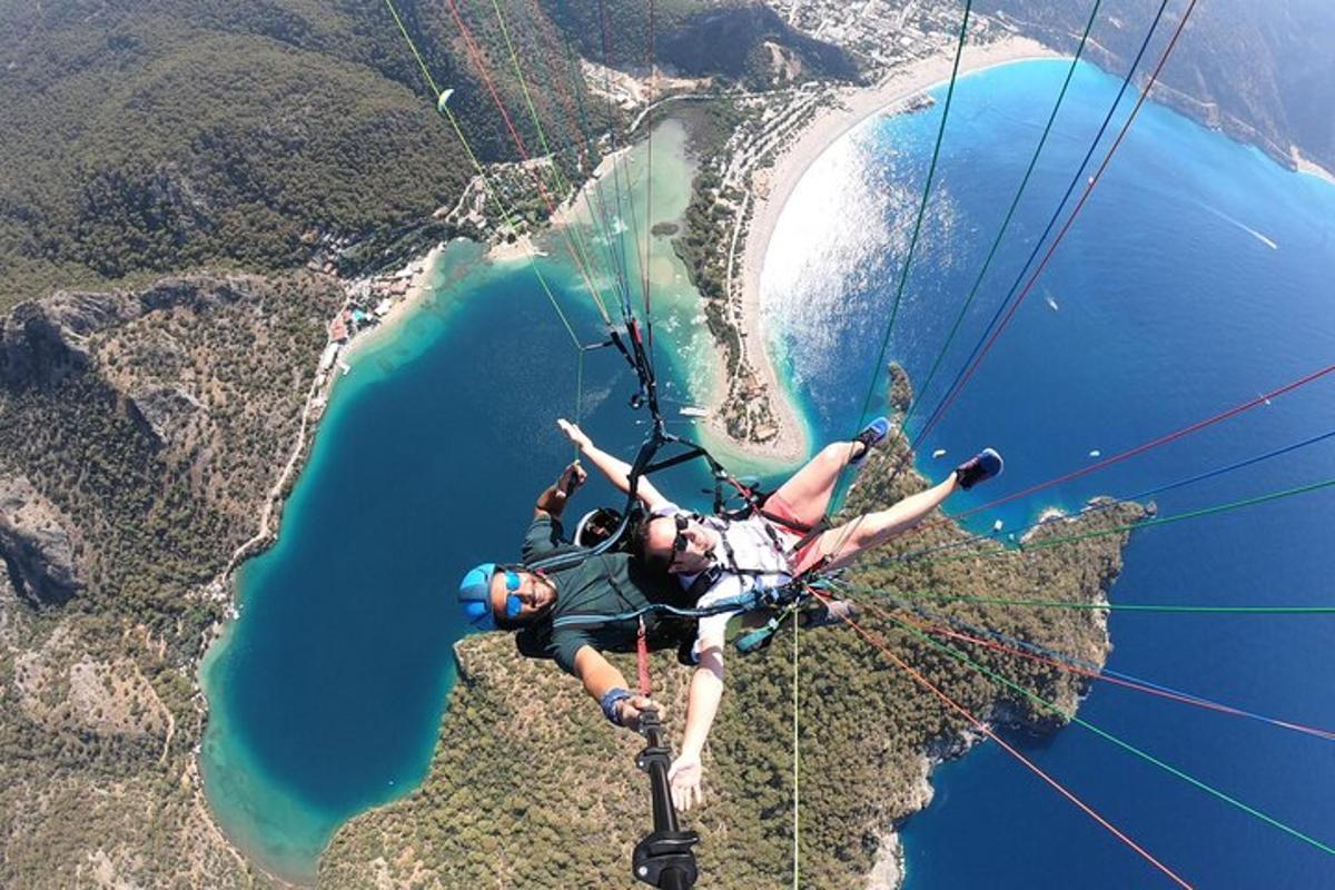 osoba visící na padáku nad vodní plochou