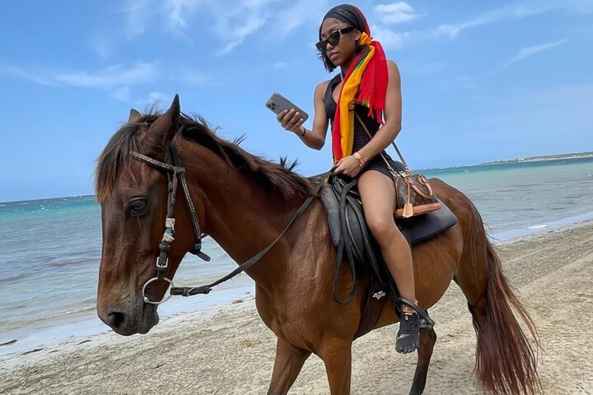 una donna sta cavalcando un cavallo sulla spiaggia