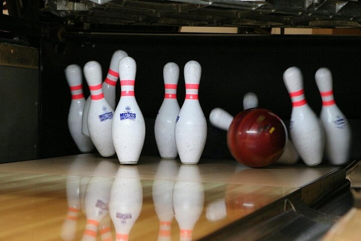 un gruppo di birilli e una mela su una pista da bowling