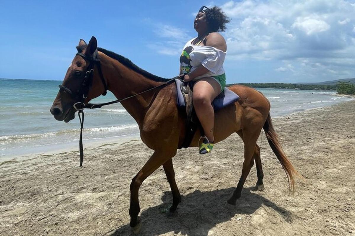 una donna a cavallo sulla spiaggia