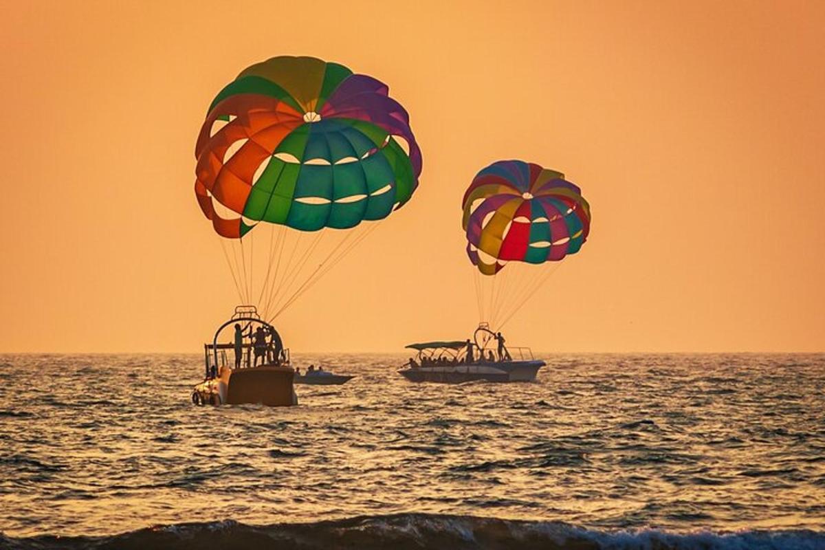 two people are riding on parachutes in the ocean