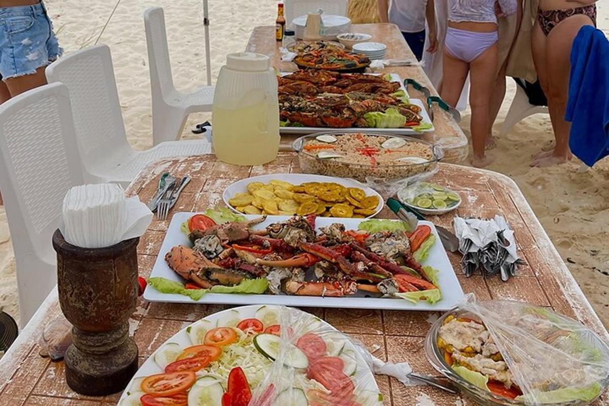 a table with several plates of food on a beach