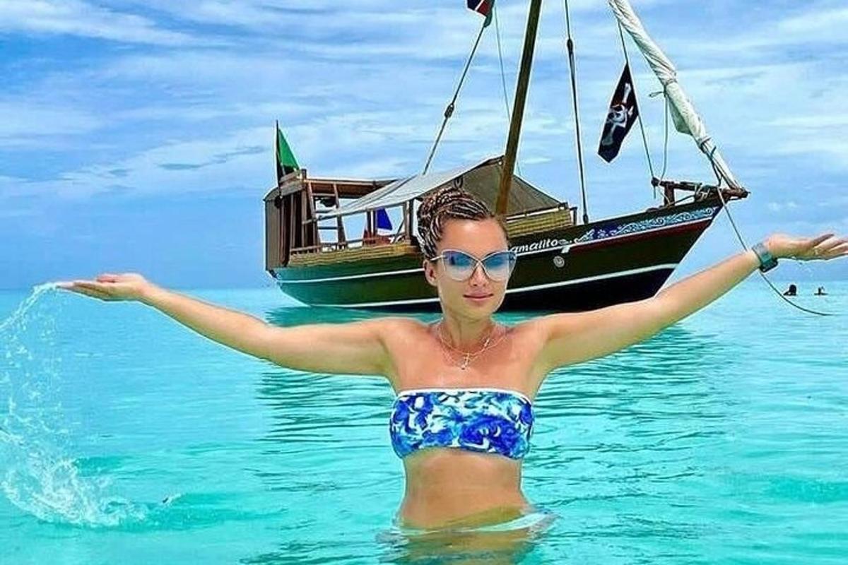 una donna in acqua davanti a una barca