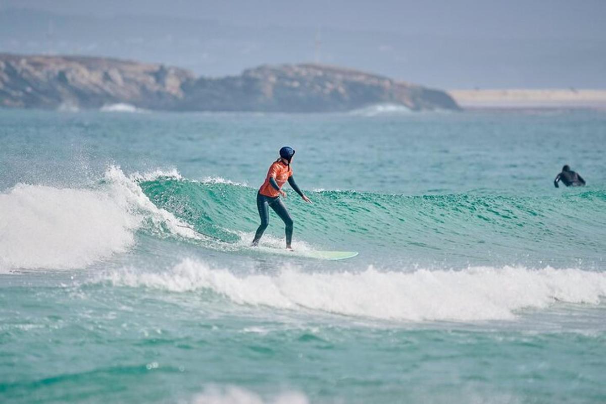 eine Person, die auf einem Surfbrett im Meer auf einer Welle reitet