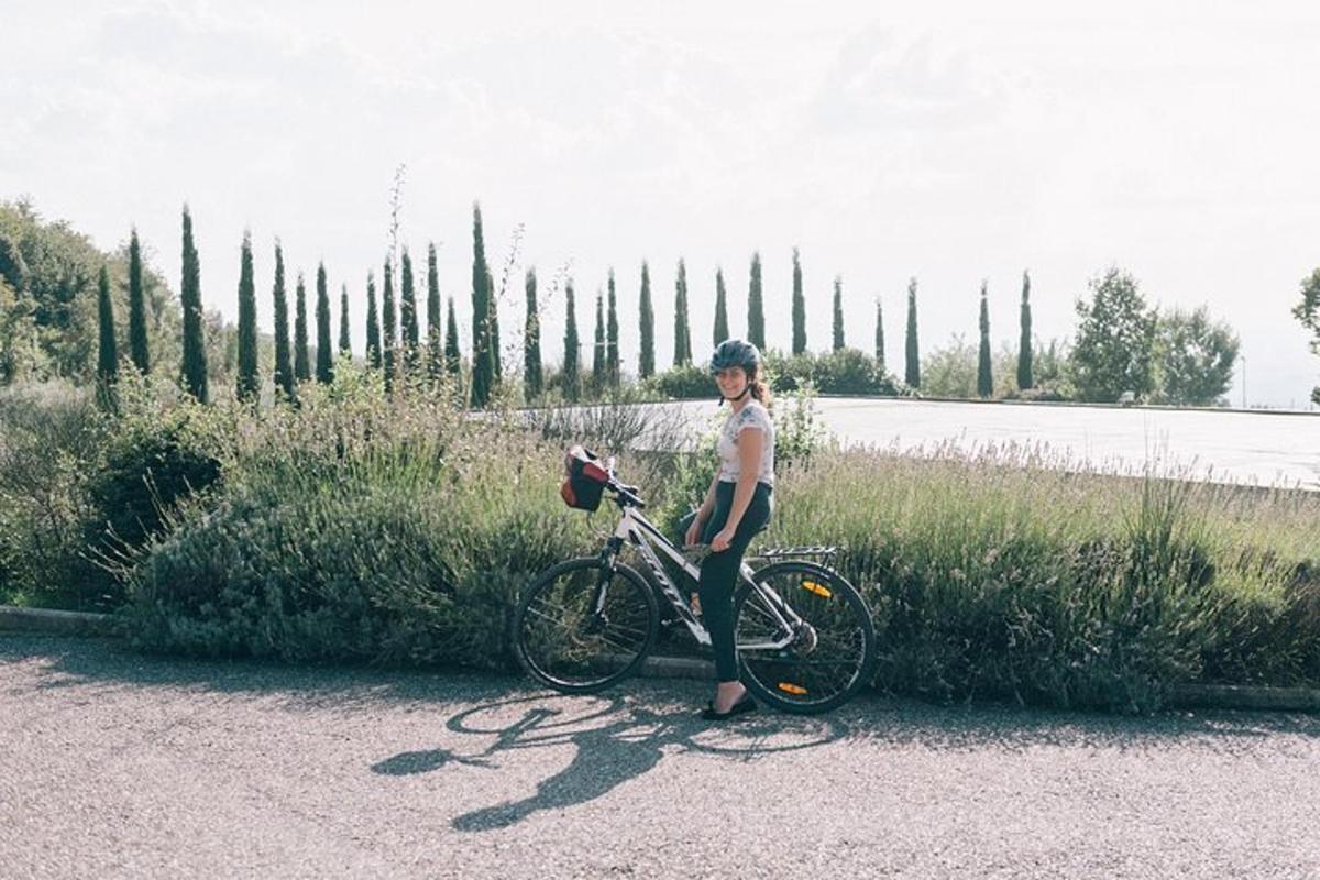 una dona dreta al costat d'una bicicleta a la carretera