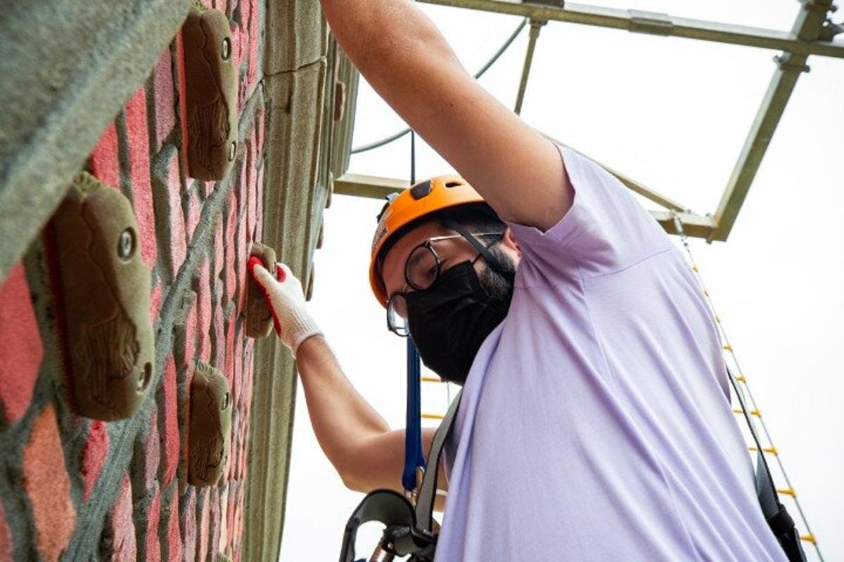 a person wearing a helmet climbing a wall