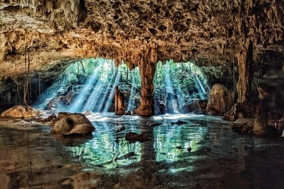 una grotta con una cascata e una pozza d'acqua