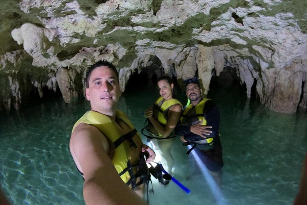 tre persone in acqua in una grotta