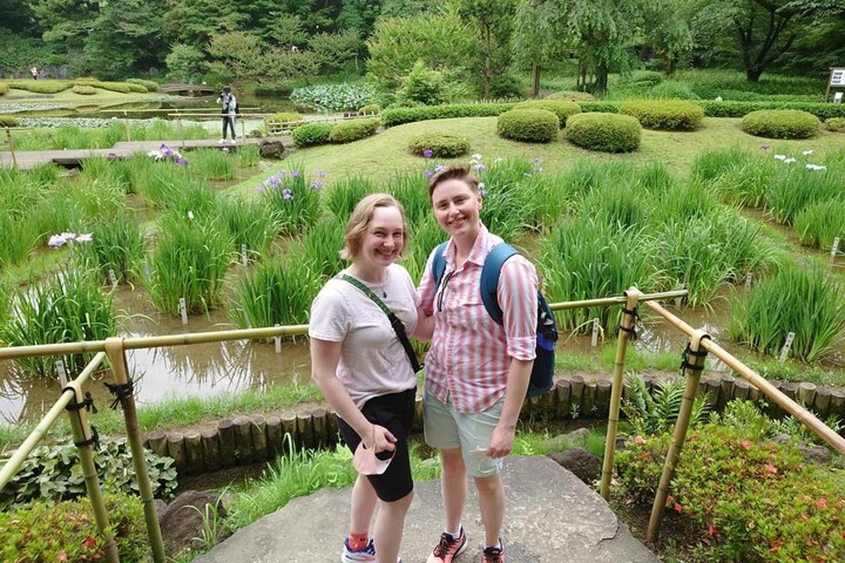 Dos personas de pie en una pasarela en un jardín.