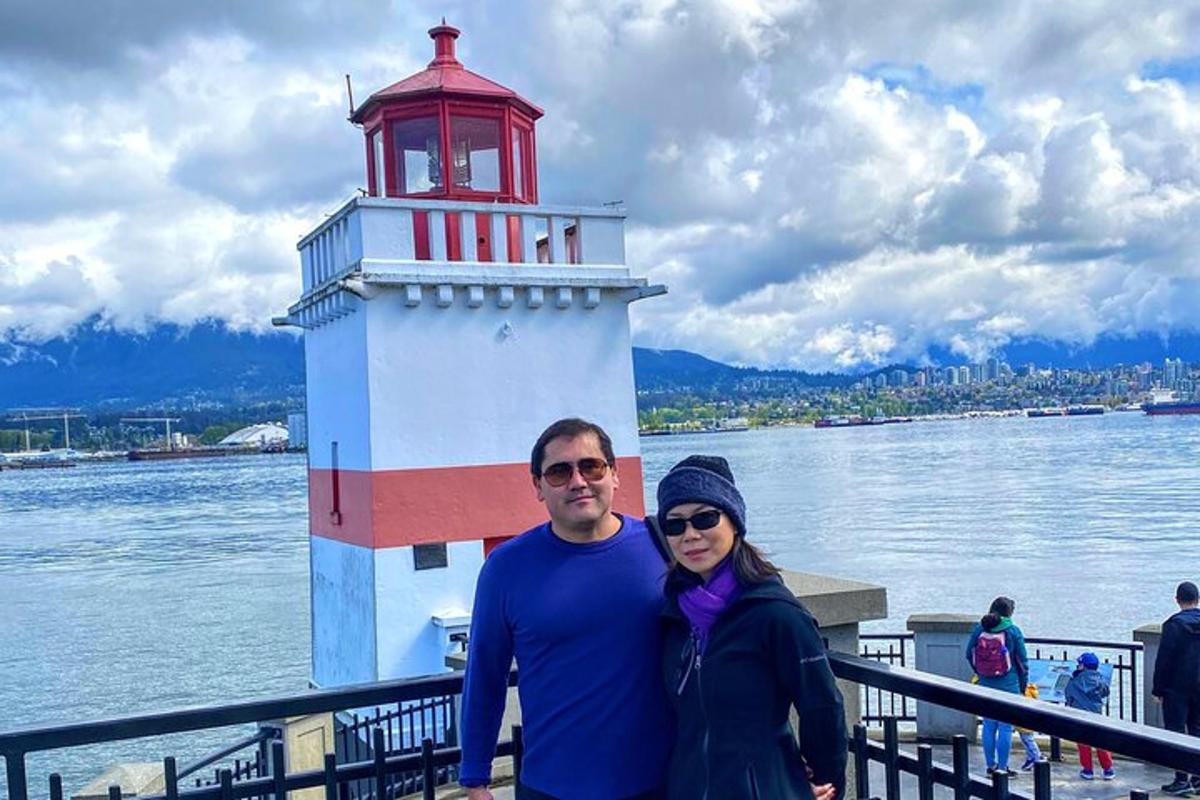 um homem e uma mulher em pé em frente a um farol