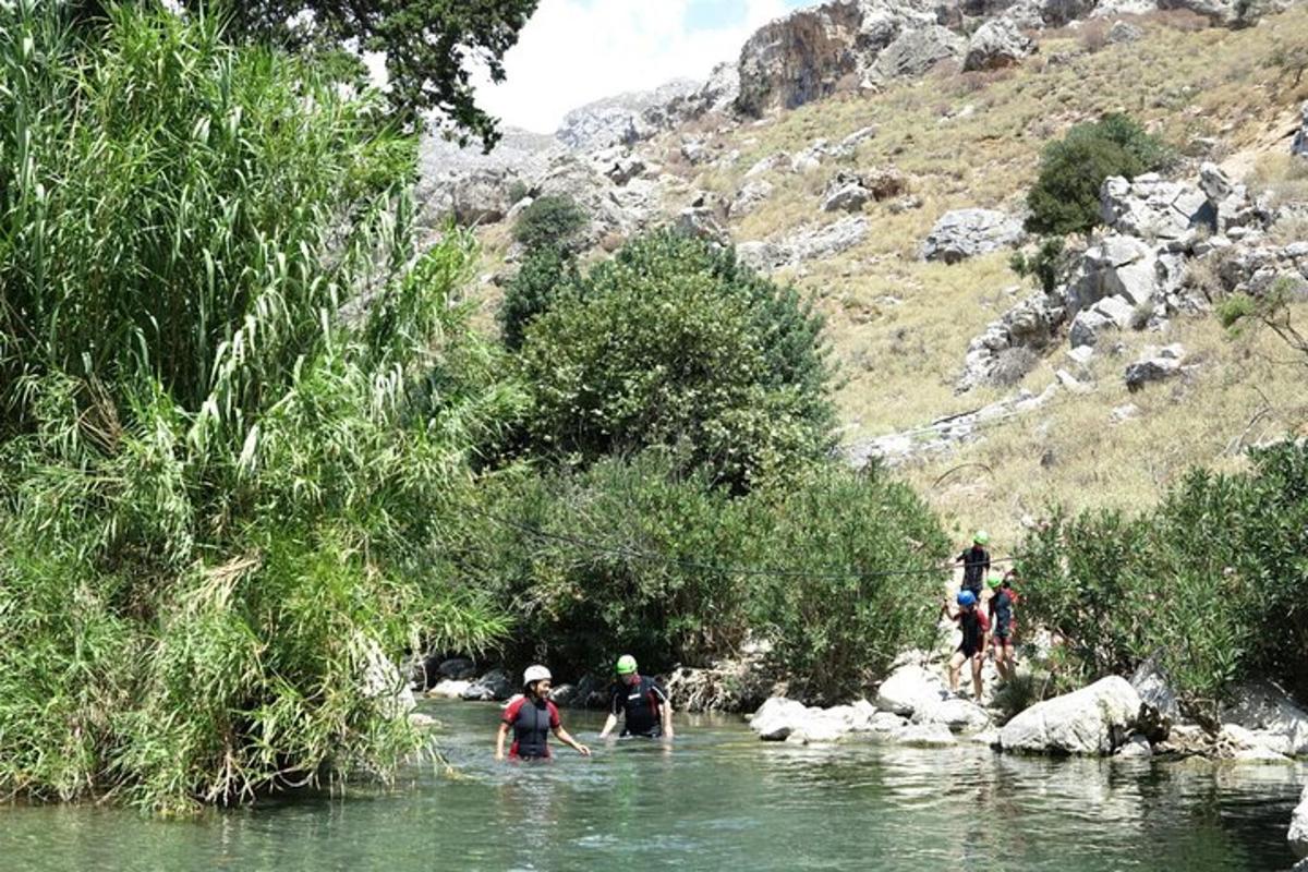 un gruppo di persone che attraversa un fiume in acqua
