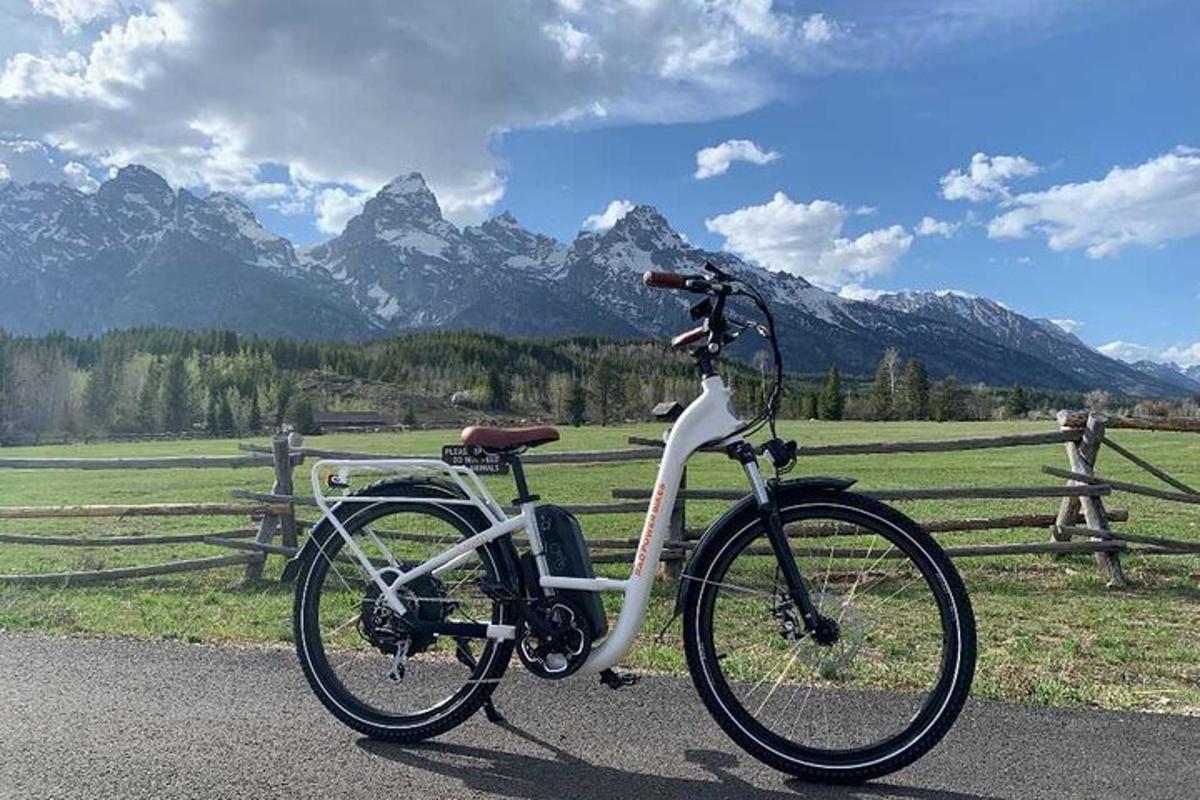 uma bicicleta estacionada em uma estrada com montanhas ao fundo