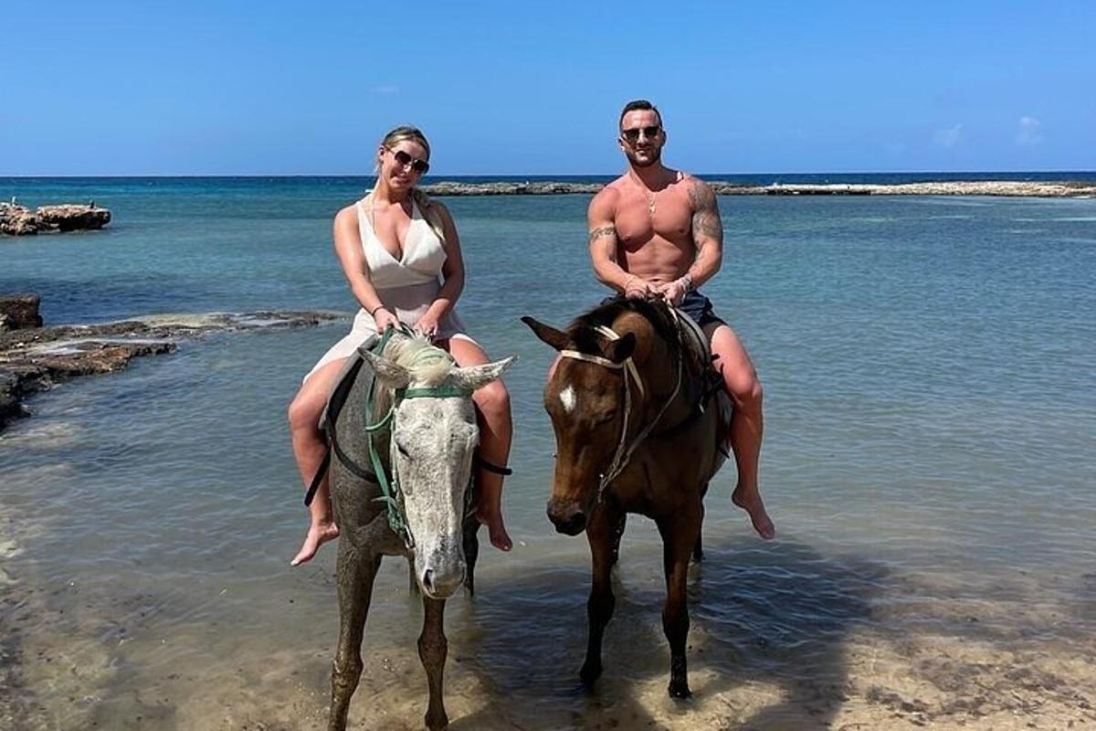 moški in ženska jahata konja na plaži