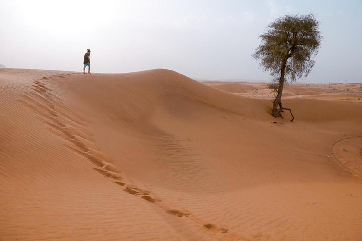 a man standing on top of a sand dune