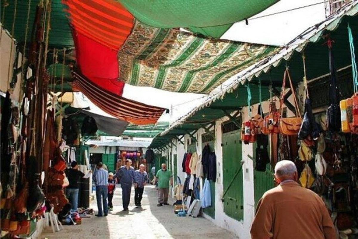 Un grupo de personas caminando por una calle en un mercado.