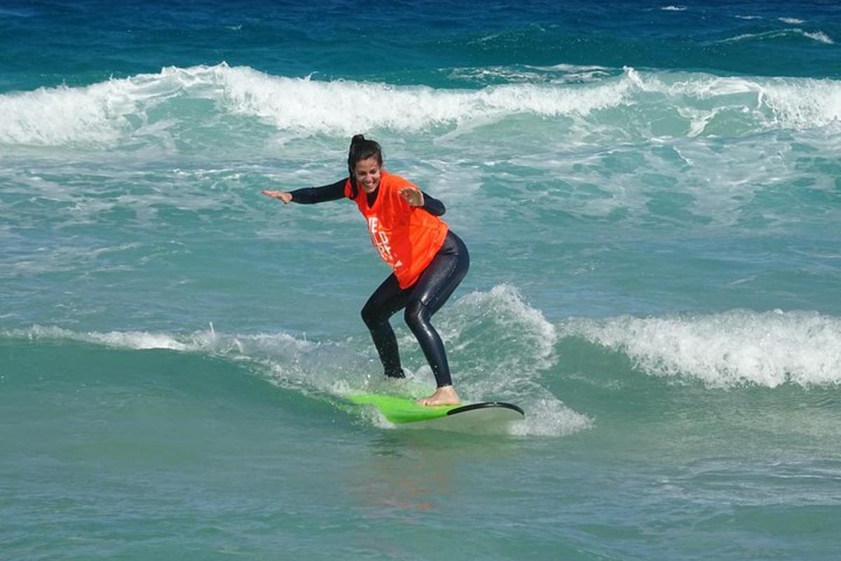 una dona cavalcant una onada sobre una taula de surf a l'oceà