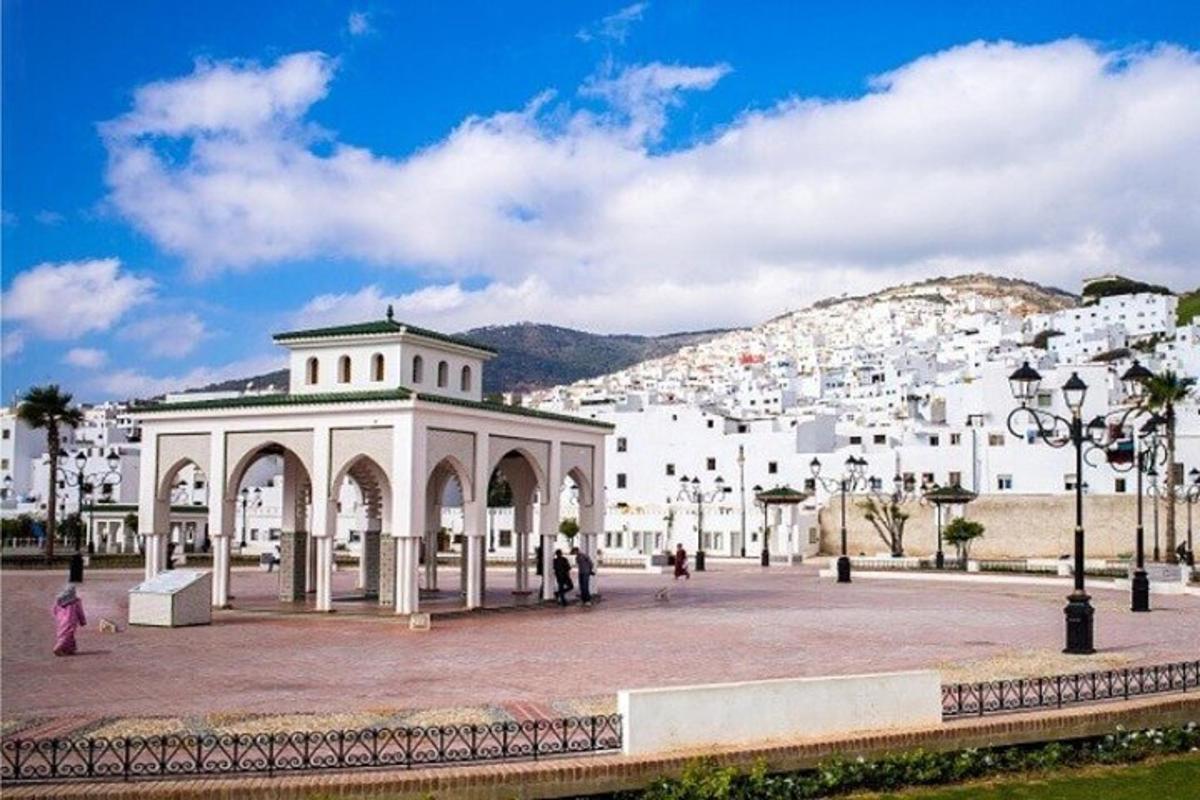 un edifici blanc amb gent caminant davant d'una ciutat