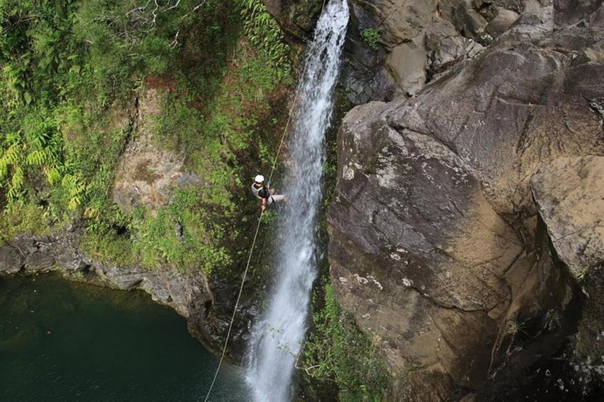 un uomo è in piedi su una corda davanti a una cascata