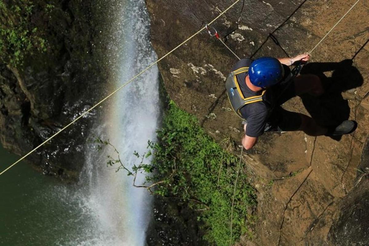 un uomo in piedi su una roccia accanto a una cascata