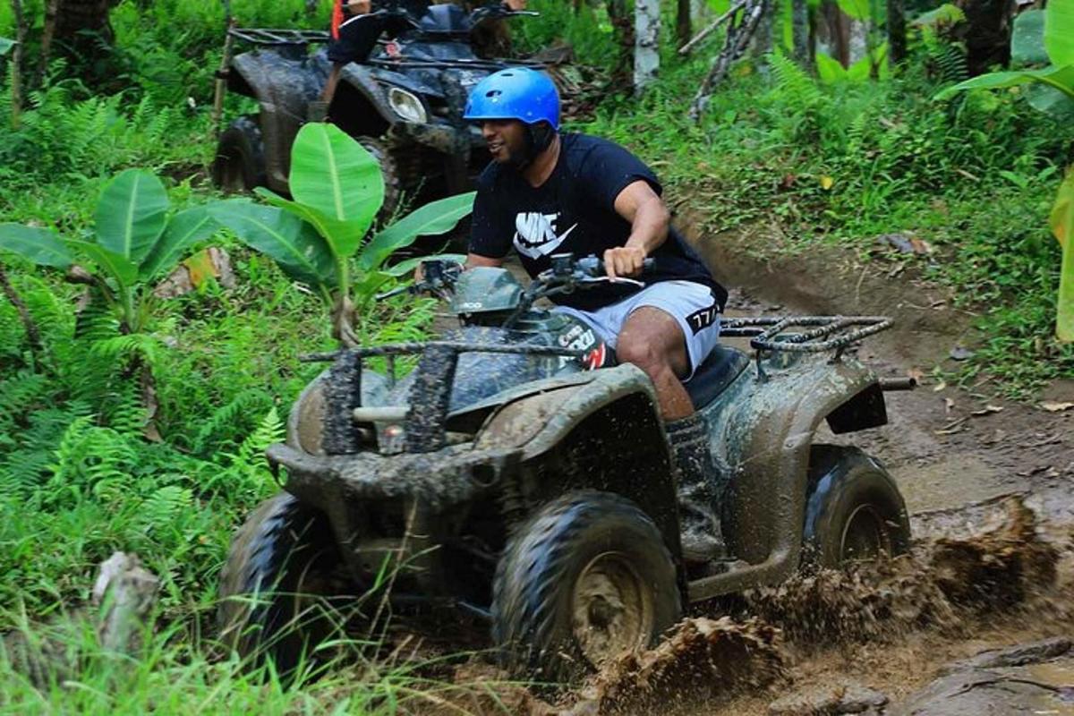 a man riding on a four wheeler in the mud