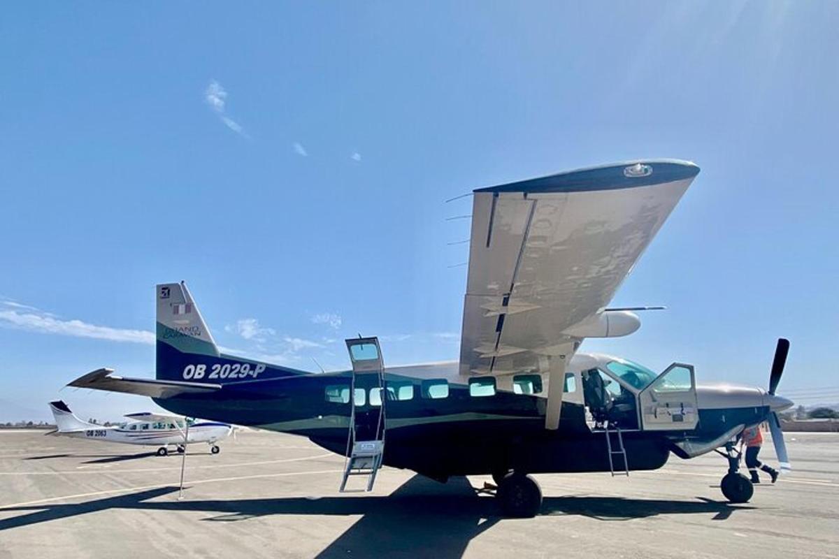 um pequeno avião azul parado na pista