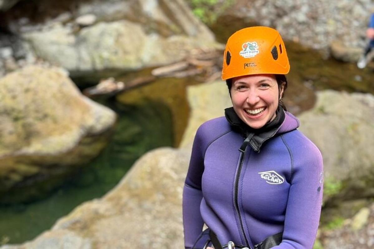 a woman wearing an orange hat standing on some rocks