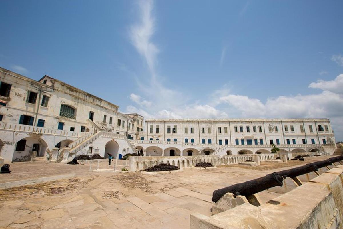 a large white building with stairs in a courtyard