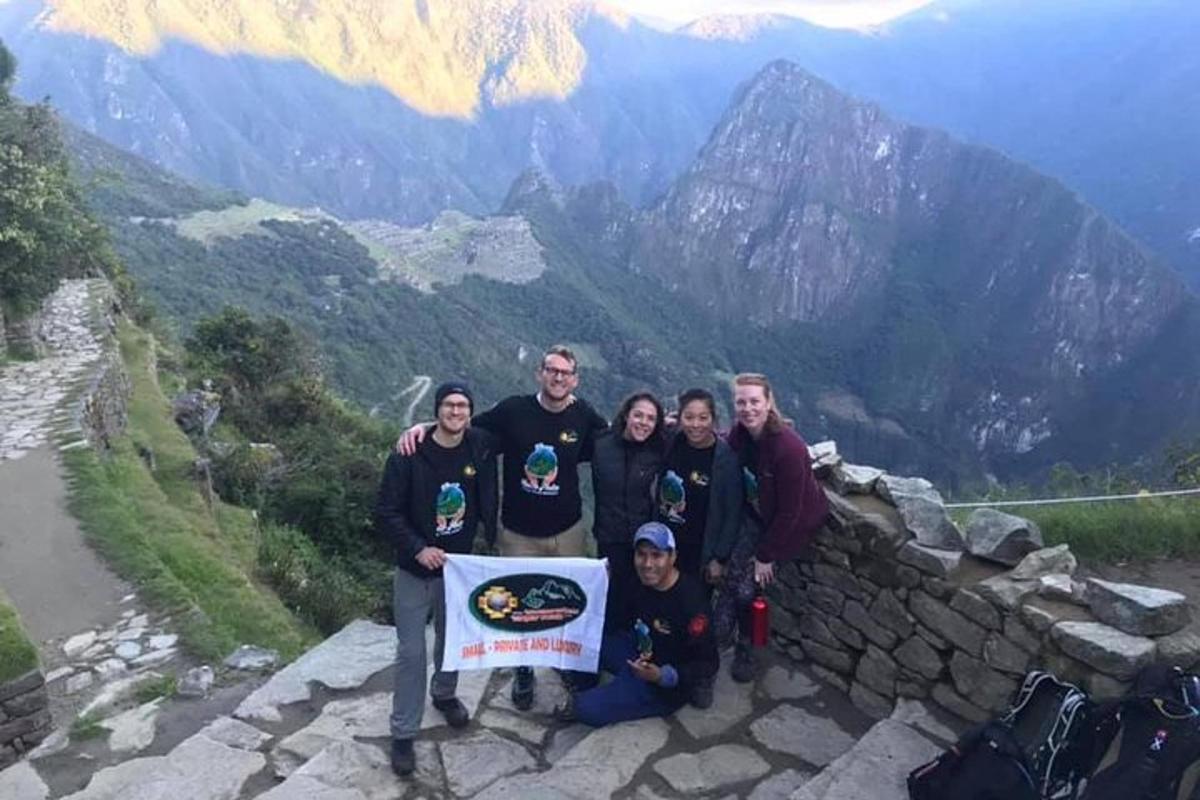 un grup de oameni care pozează pentru o fotografie pe un munte
