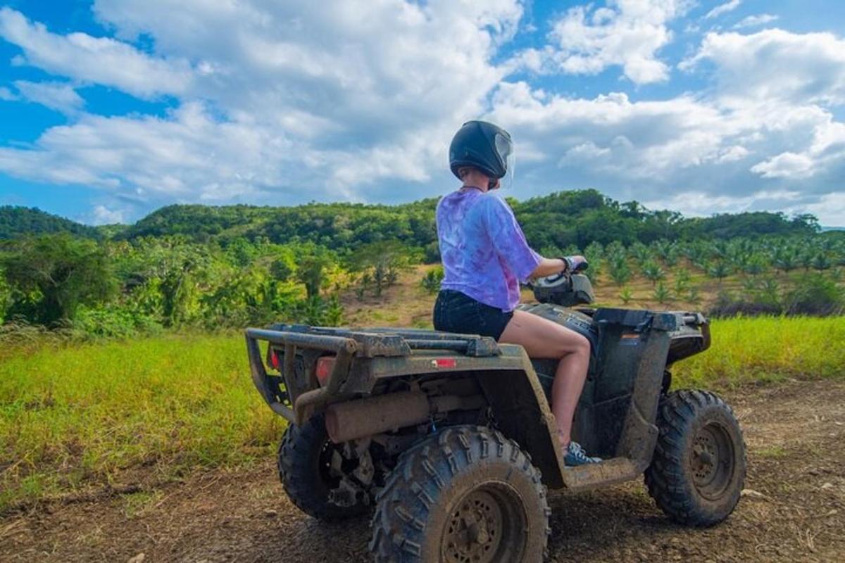 a child riding on the back of an atv on a field