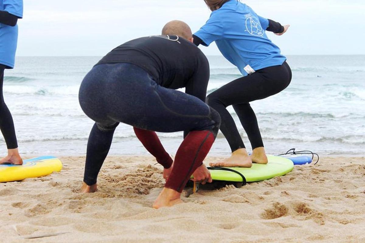 a group of people standing on a surfboard on the beach