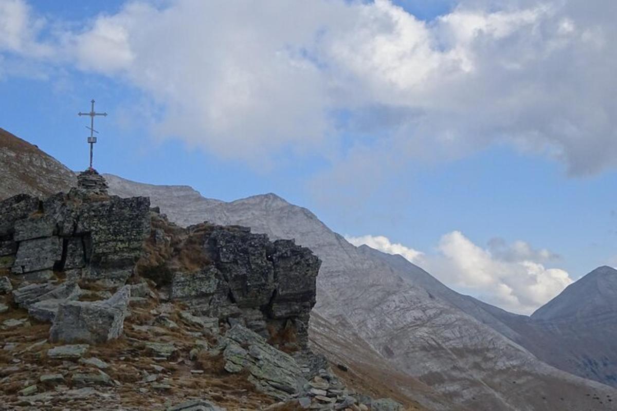 una croce sulla cima di una montagna rocciosa