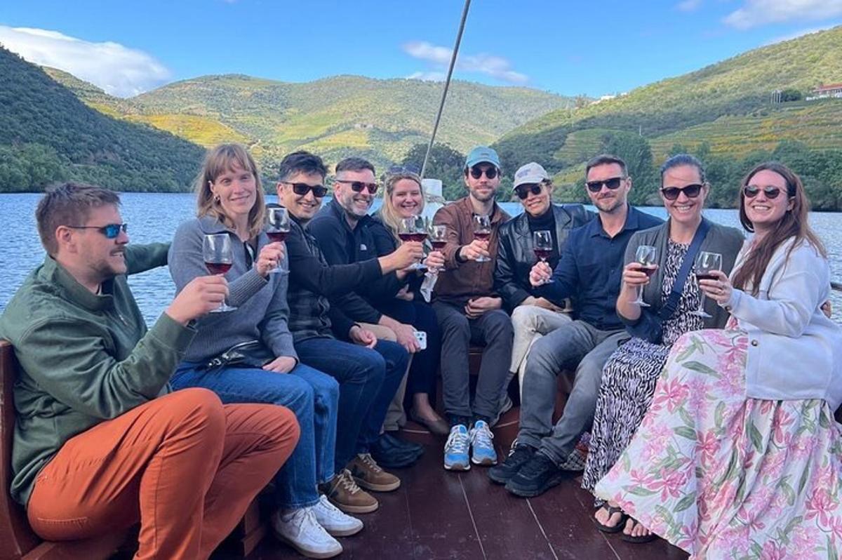 a group of people sitting on a boat holding wine glasses