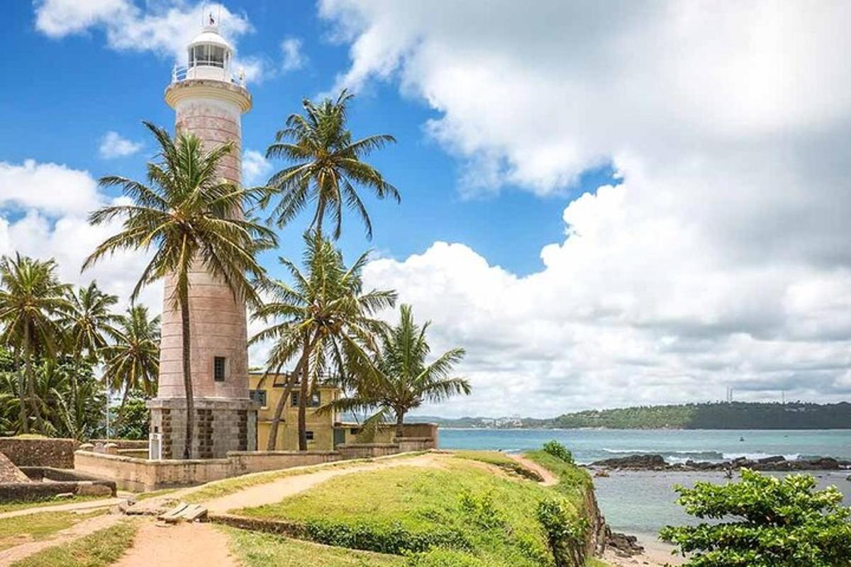 um farol em uma colina próxima a um corpo d'água