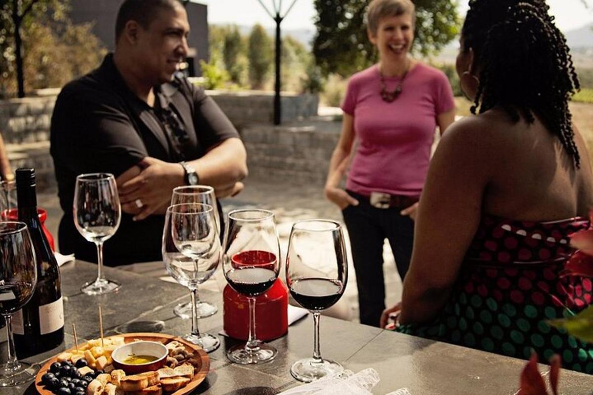 a group of people standing around a table with wine glasses