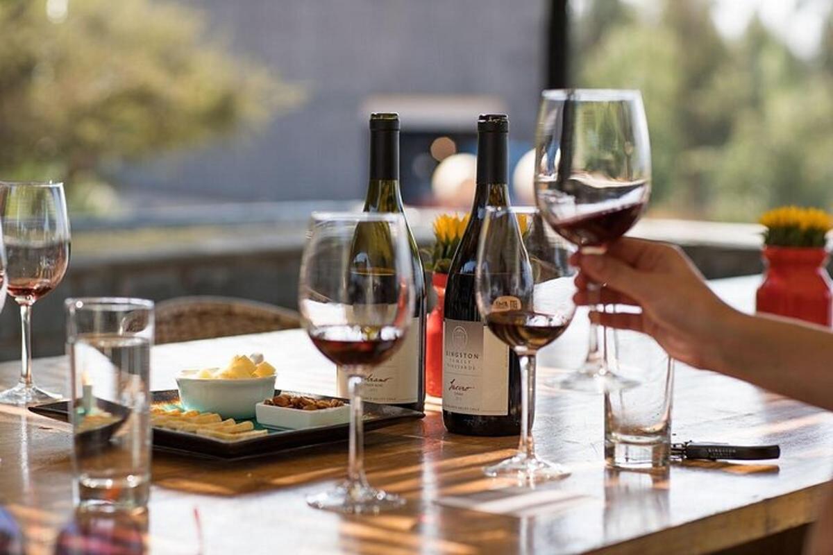 a person holding up two glasses of wine on a table