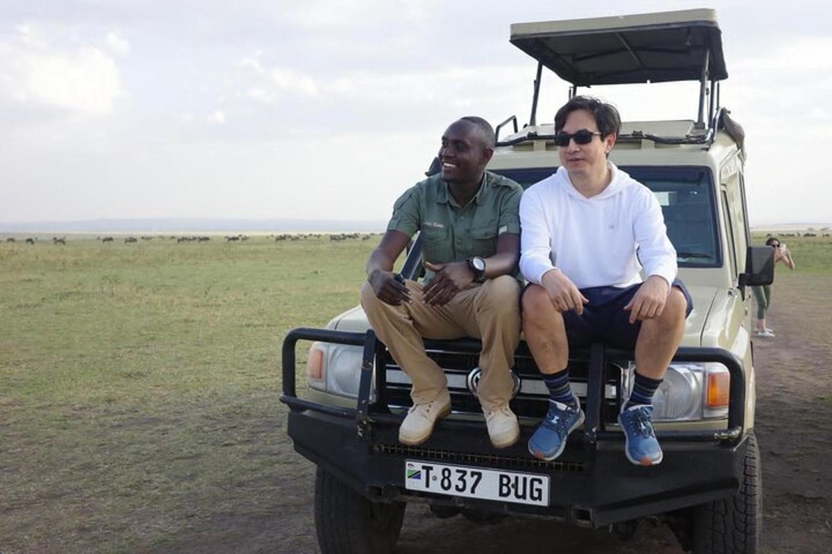 two men sitting on the back of a truck