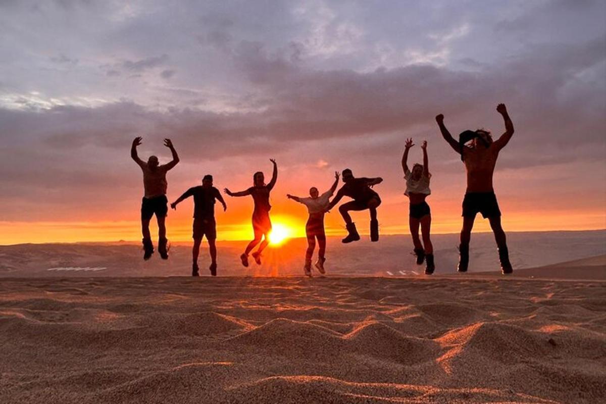 một nhóm người nhảy trên bãi biển lúc hoàng hôn