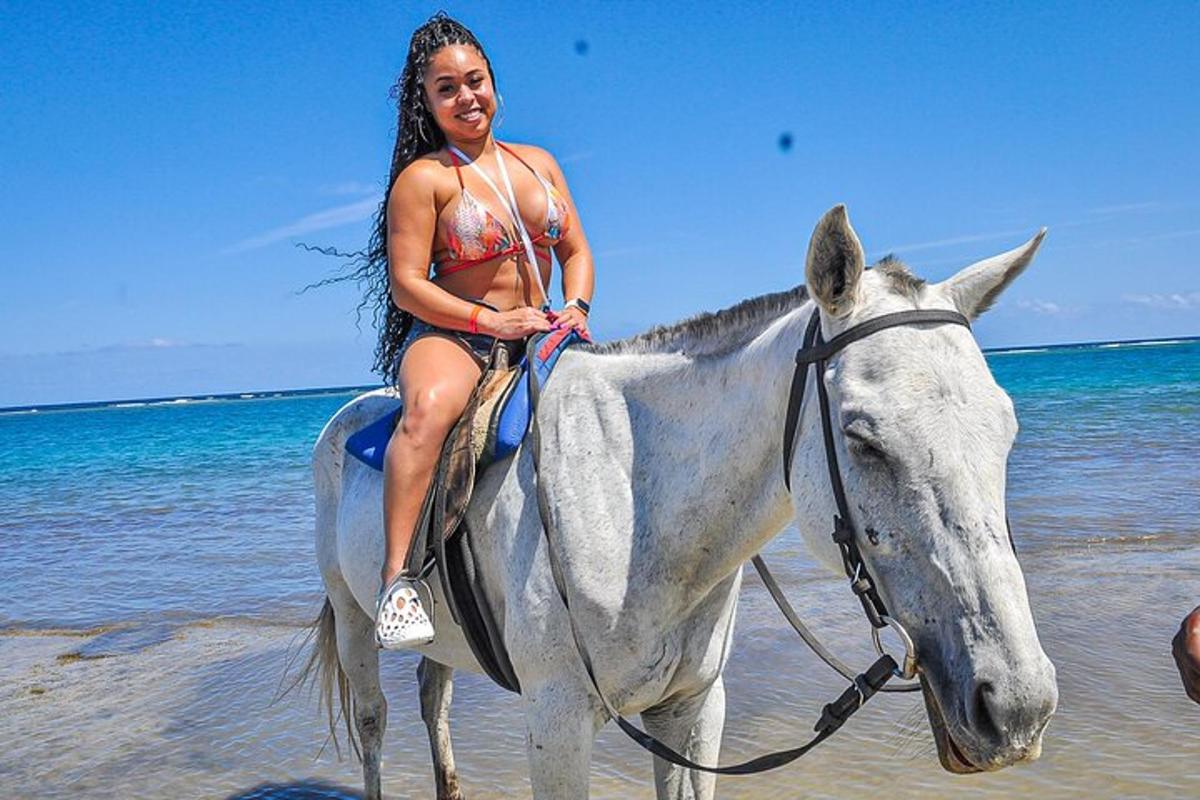 seorang wanita berbikini menunggang kuda di pantai