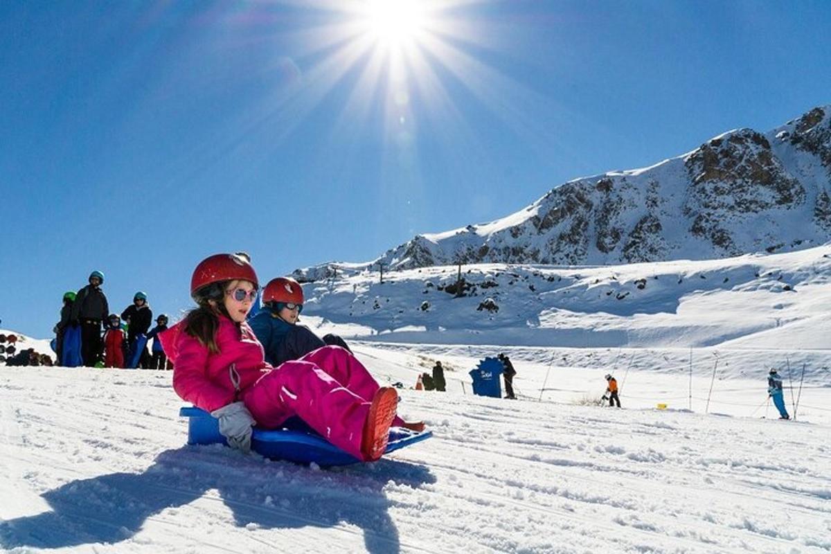 una ragazza seduta sulla neve su una pista da sci