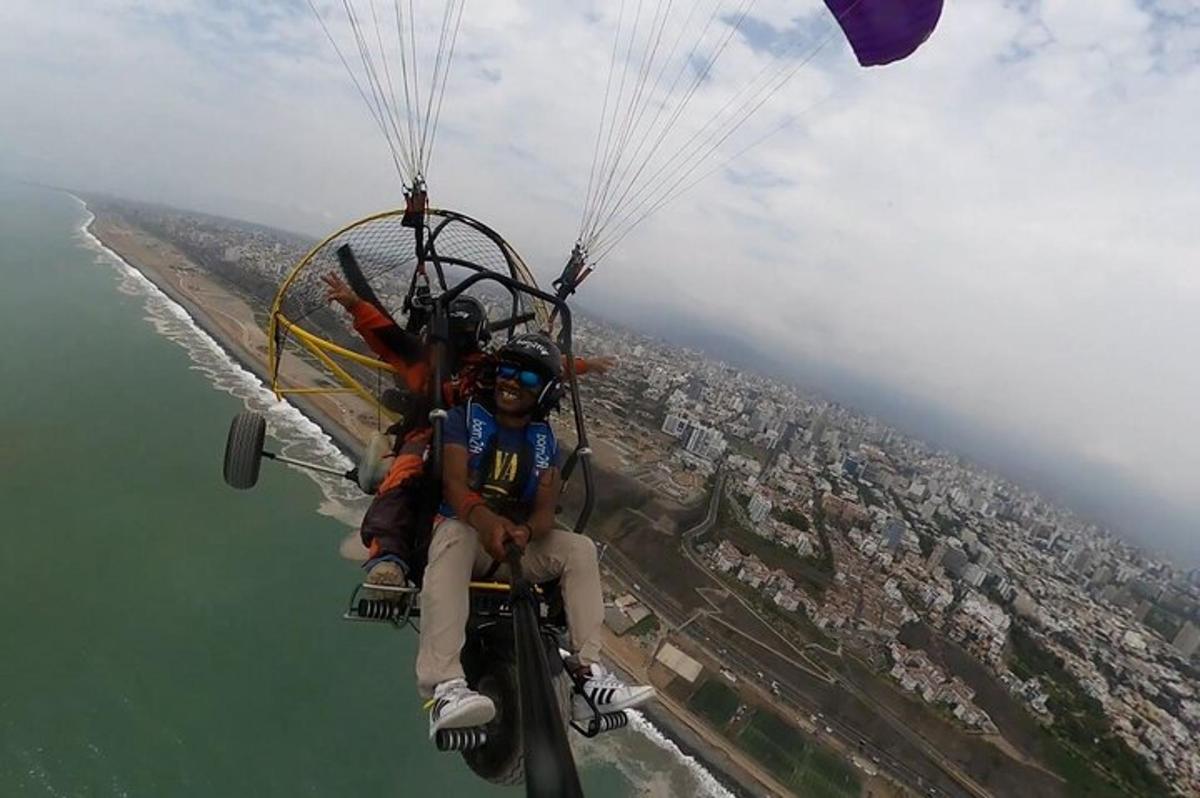 twee mensen rijden met een parachute over het water