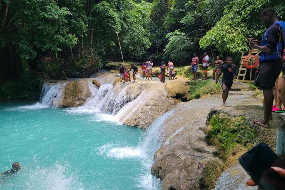 un gruppo di persone in piedi davanti a una cascata