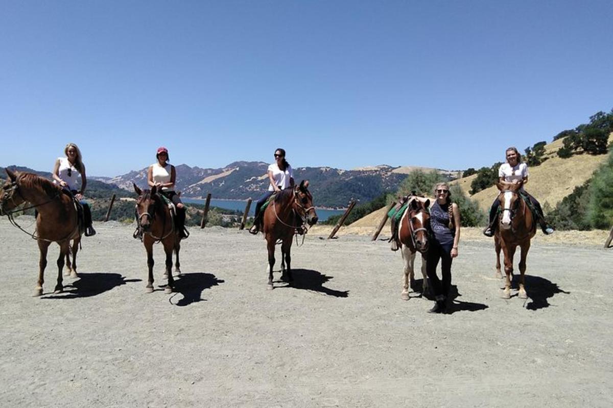 a group of people riding horses on the beach