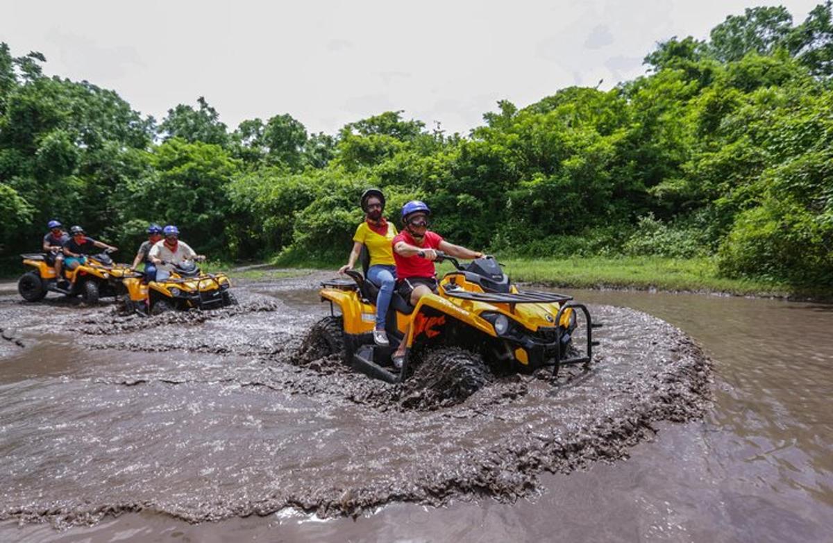un grup de persones que circulen en quads per un riu