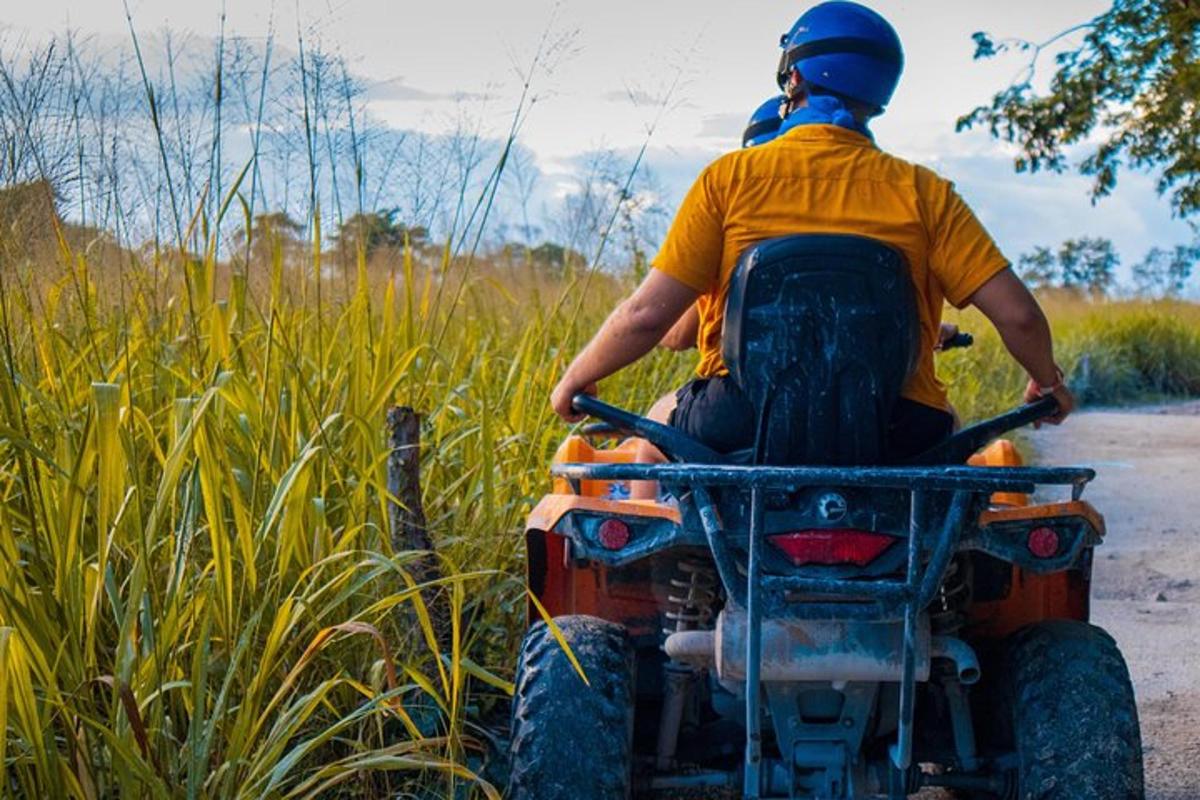 un uomo che guida un quad lungo una strada sterrata