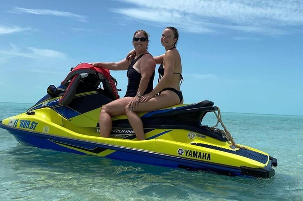 dues persones assegudes en una moto aquàtica a l'aigua
