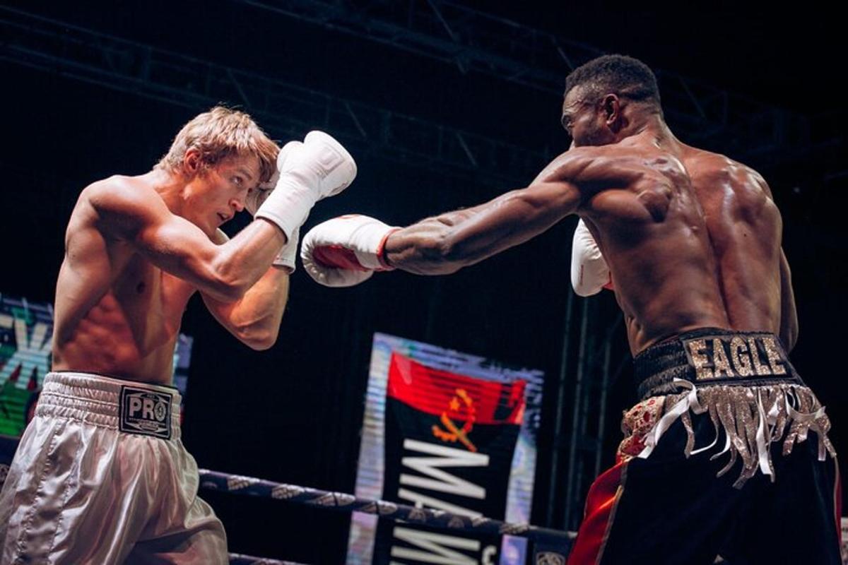 Dos hombres están boxeando en un ring de boxeo.