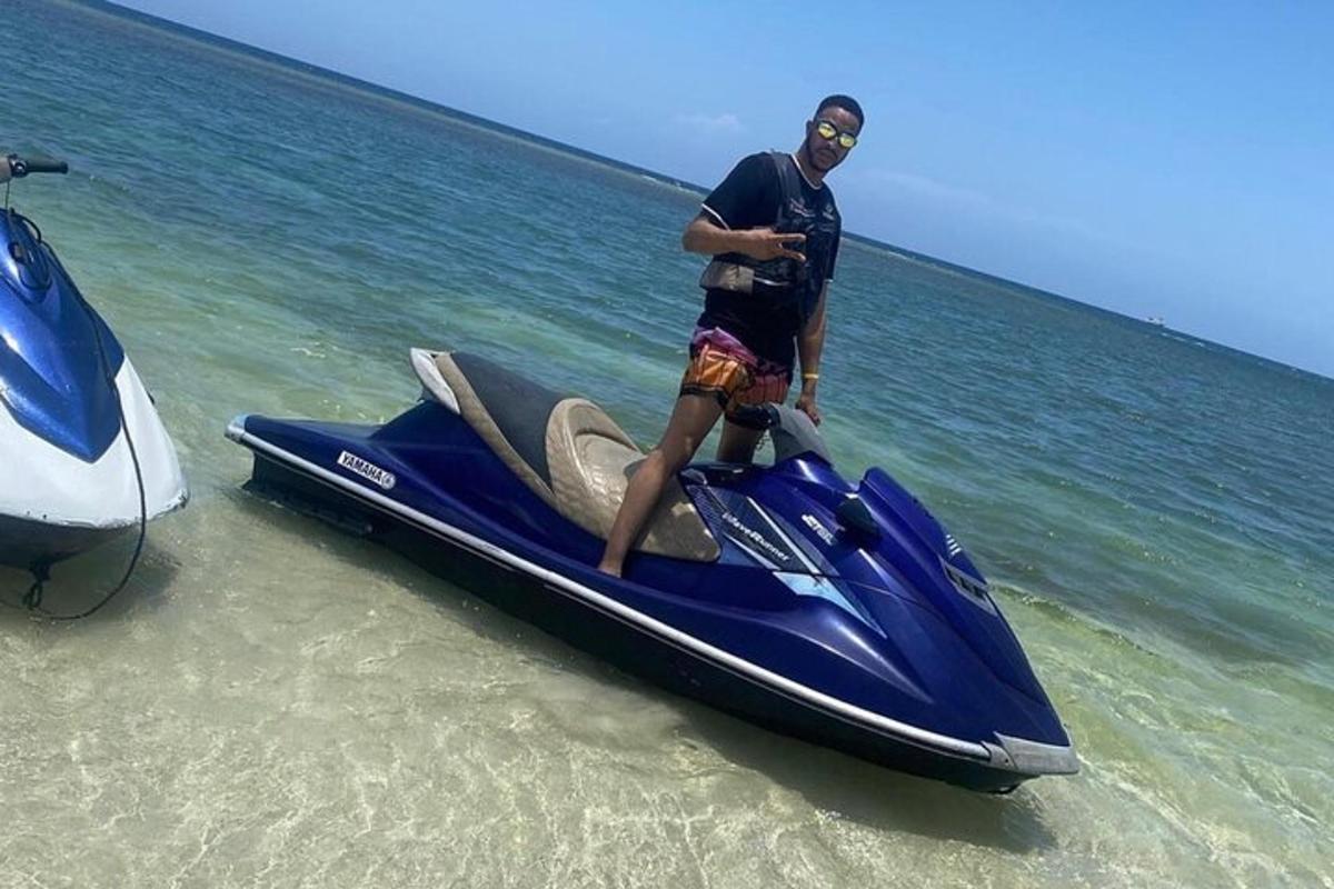 un bărbat care stă pe un jet ski pe plajă