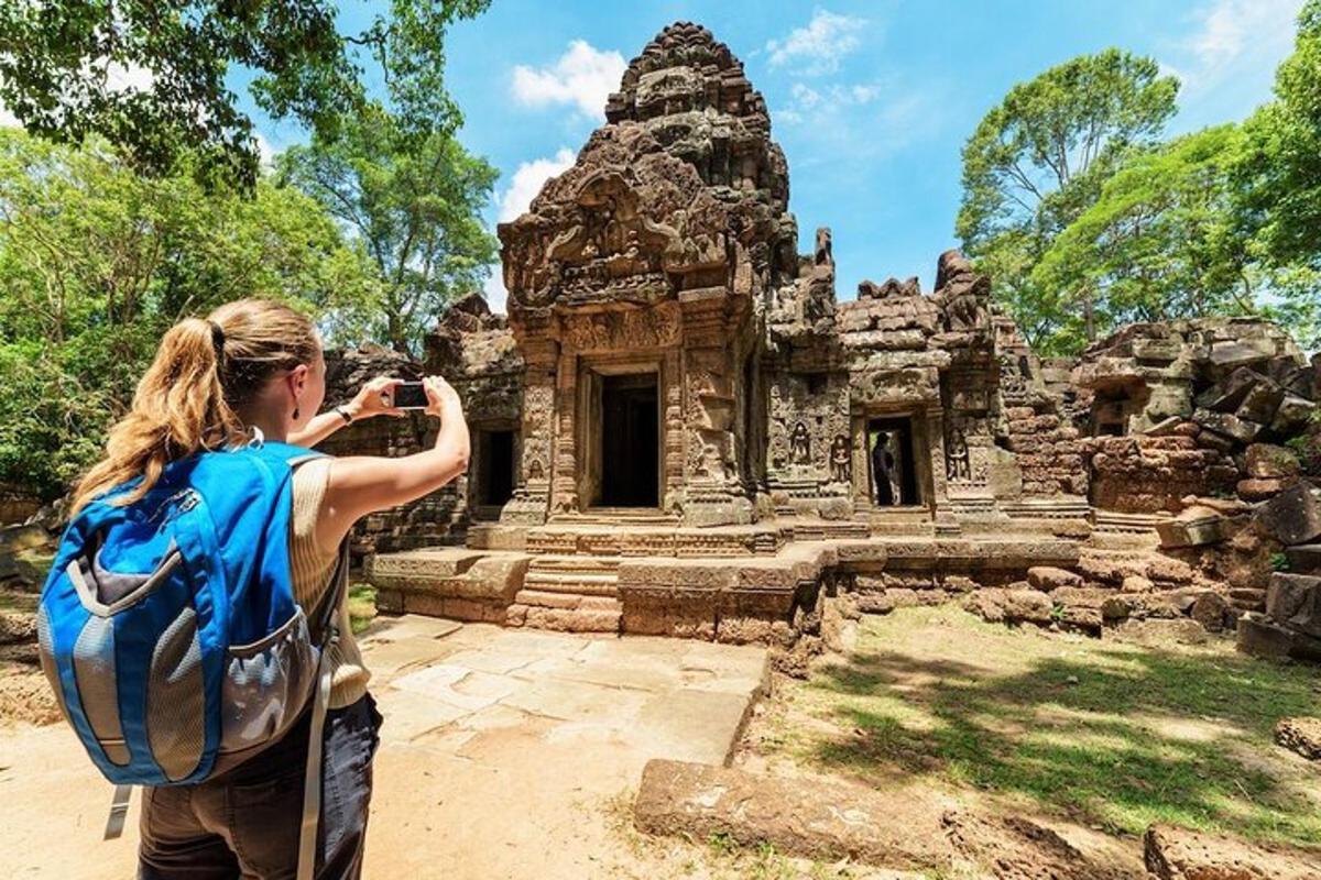 một người phụ nữ đeo ba lô đang chụp ảnh một tòa nhà