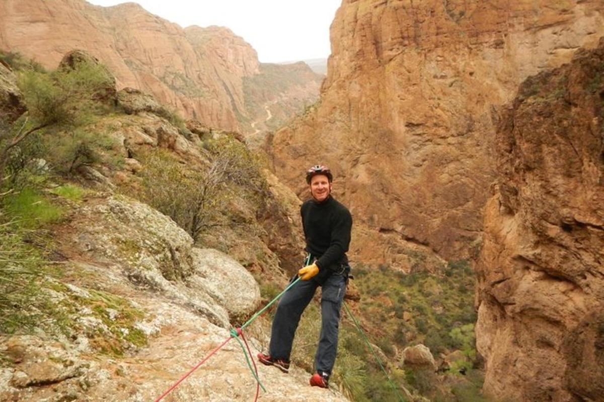 un home sosté una corda en un canyó