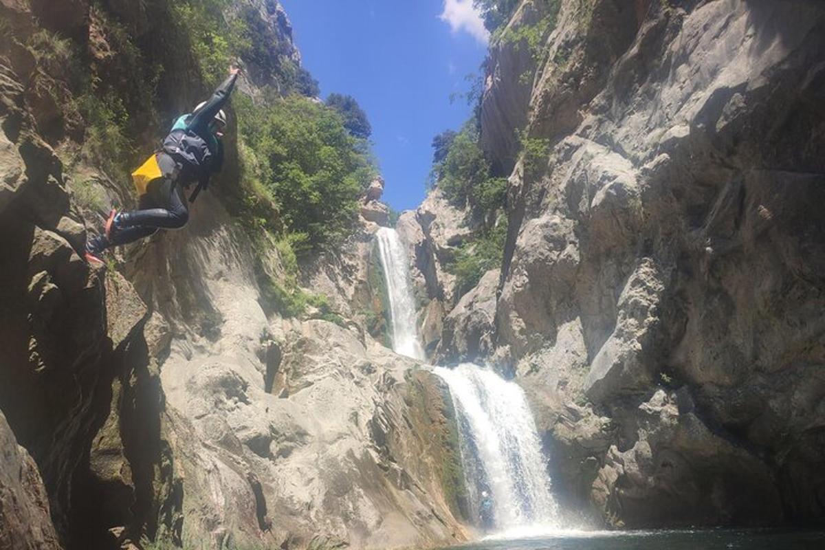 una persona saltant d'un penya-segat a una cascada